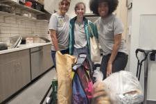 Three Colectivo de Paz volunteers preparing food in kitchen