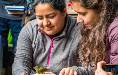 A study abroad student sitting with an elderly woman from Ecuador