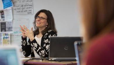 斯泰西Freedenthal speaks animatedly in a classroom.